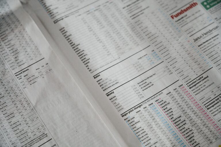 Newspaper page filled with financial data tables representing SEO revenue forecast modeling